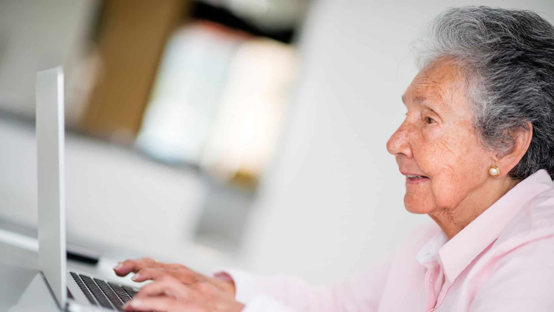 an elderly women learning to use computer
