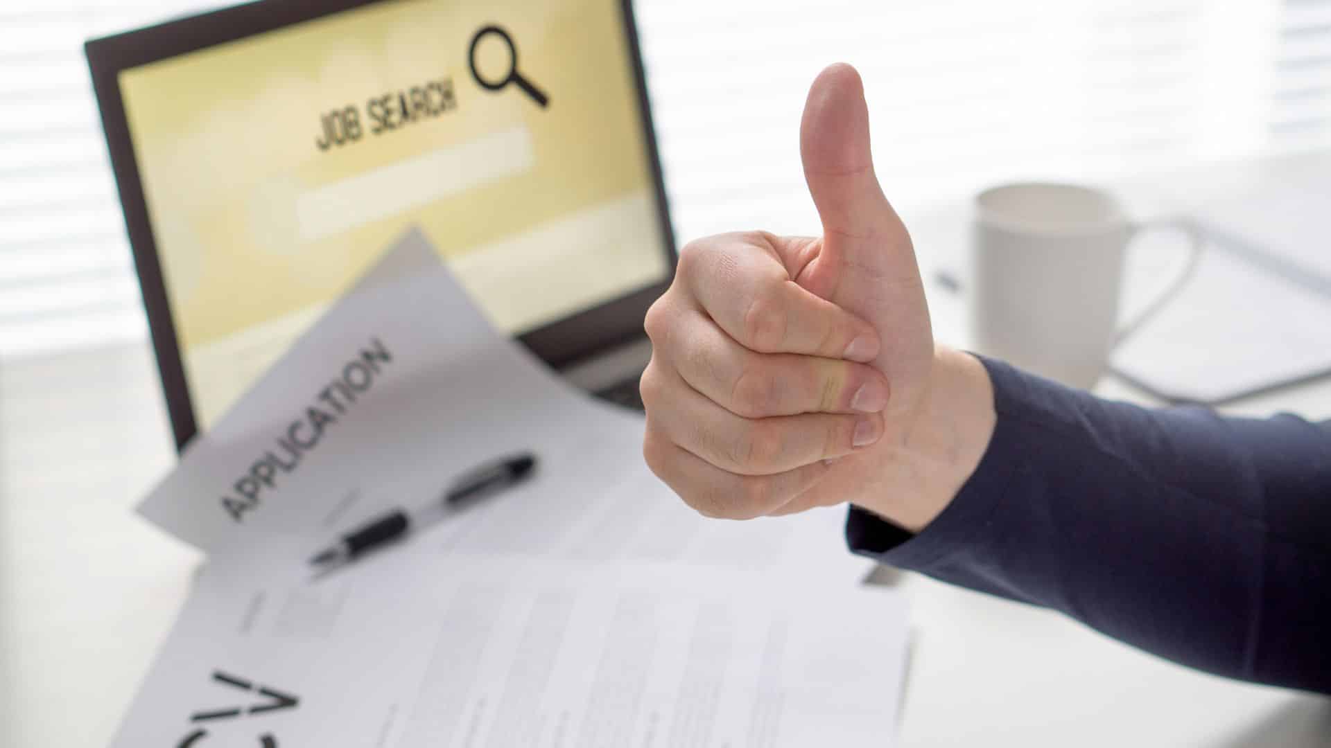 an applicant searching for job and giving thumps up after applying for the job on computer